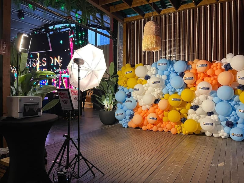 Cabina foto SelfieFun lângă un perete de baloane cu sigla Molson Coors